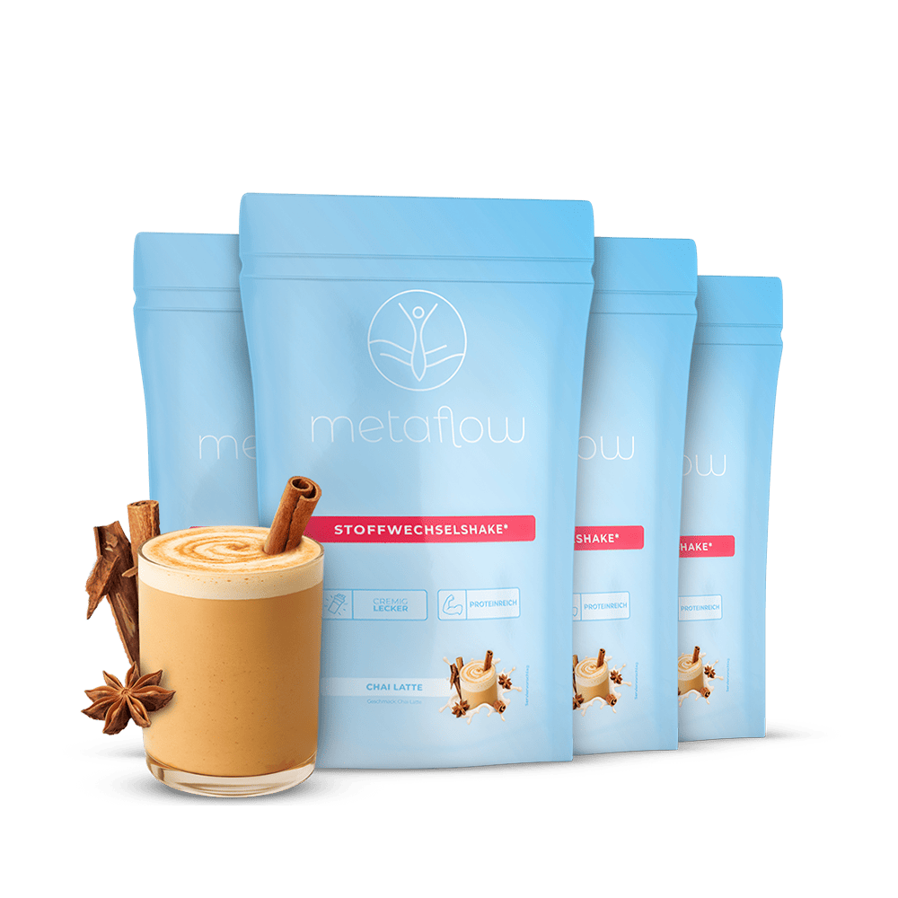 Vier Beutel MetaFlow Stoffwechselshake steht mittig, links neben dem Beitel steht ein mit Zimtstangen, Sternanis verziertes Glas des Chai Latte Shakes als Dekoration.